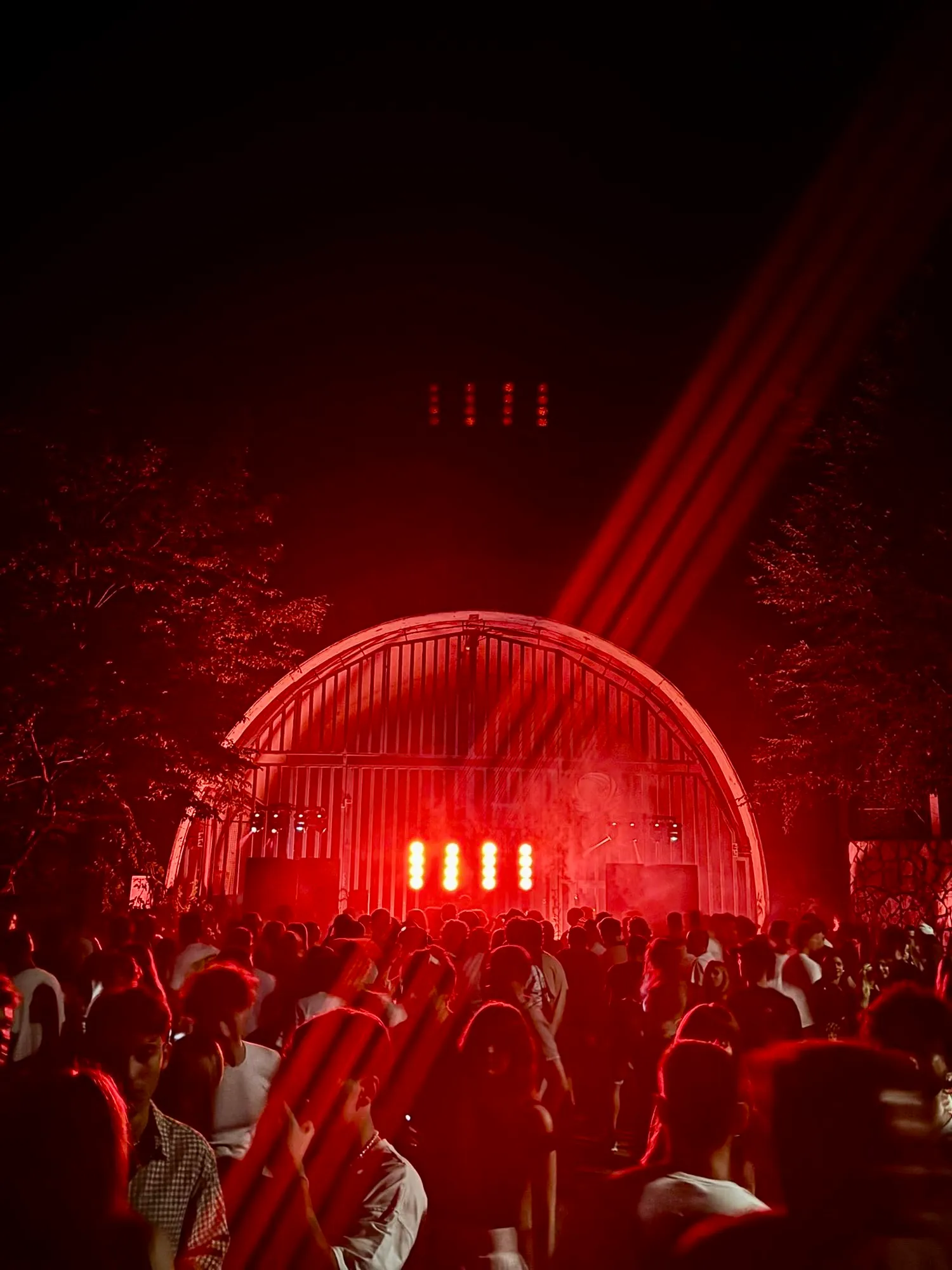 Il pubblico davanti a un palco illuminato di rosso a una festa di THE_VAST1